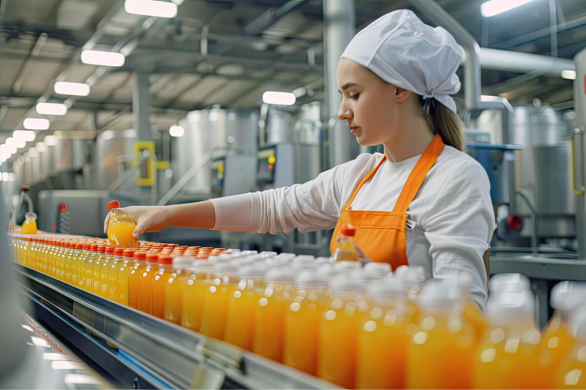 female-worker-inspects-bottled-fruit-juice-beverage-factory-conveyor-belt-quality-control